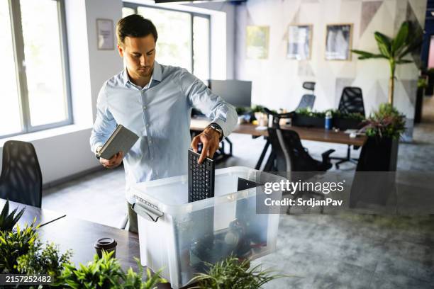 young caucasian businessman packing his belongings from the office, after he get fired - quitting job stock pictures, royalty-free photos & images