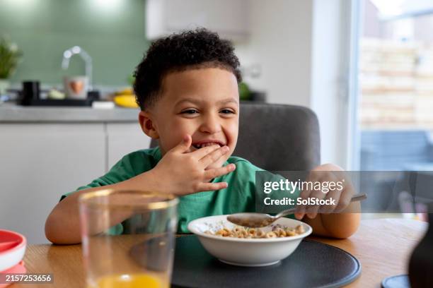 young boy having fun at breakfast time - breakfast cereal stock pictures, royalty-free photos & images