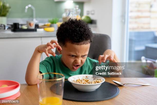 playful boy at the breakfast table - animal imitation stock pictures, royalty-free photos & images