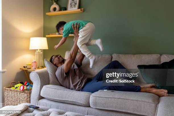 father and son playing at home - comfortabel stockfoto's en -beelden