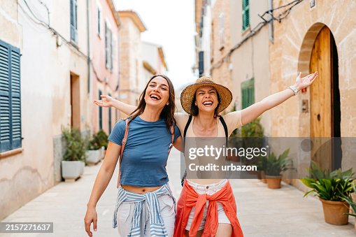 Two Female Friends Having Fun On The Street In Alcúdia In Mallorca In Spain Two Female Friends Having Fun On The Street In Alcúdia In Mallorca In Spain