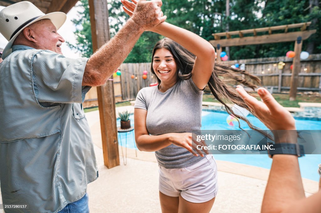 Multi generation Latino family dancing at the backyard party