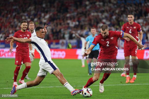England's defender Trent Alexander-Arnold fights for the ball with Serbia's defender Strahinja Pavlovic during the UEFA Euro 2024 Group C football...