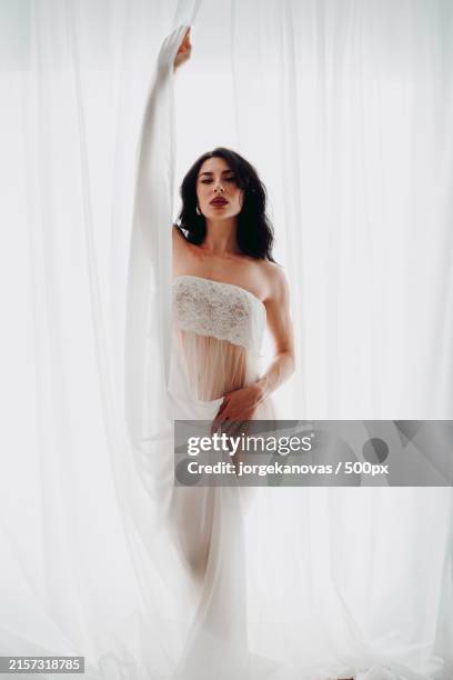 portrait of bride standing against curtain - editorial stock pictures, royalty-free photos & images