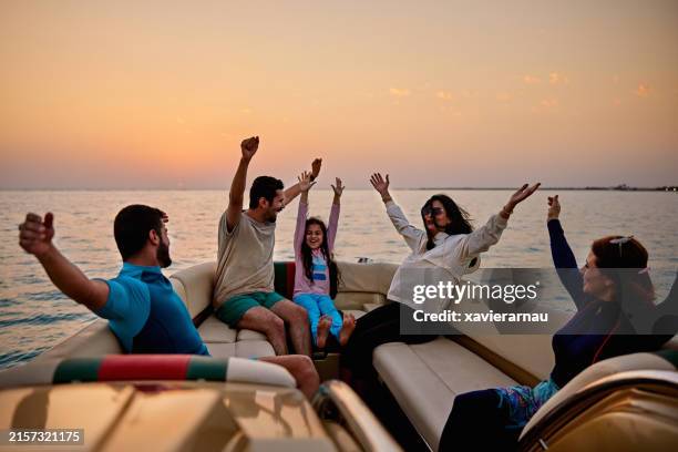 happy friends having fun sitting in speedboat on sea - red sea stock pictures, royalty-free photos & images