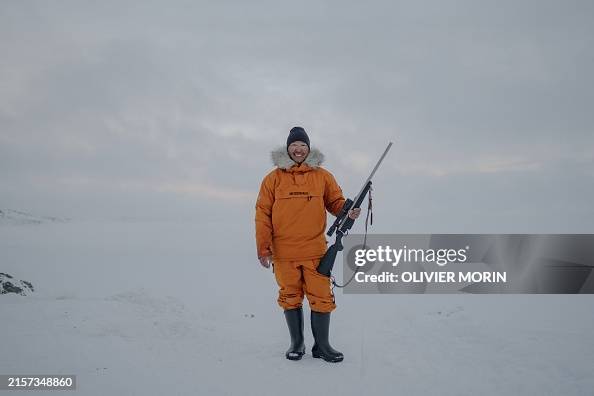 Professional Inuit hunter Martin Madsen poses with a rifle in... News ...