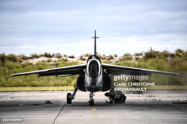 Military technician performs pre-flight checks as an Ukrainian trainee and a French military instructor get ready onboard an Alpha Jet fighter jet...