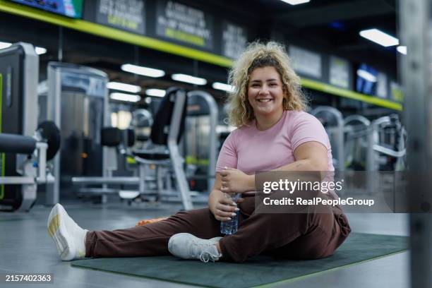 mujer joven hidratándose durante el entrenamiento en el gimnasio - obesidad fotografías e imágenes de stock