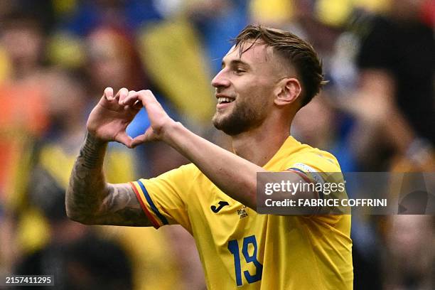 Romania's forward Denis Dragus celebrates scoring his team's third goal during the UEFA Euro 2024 Group E football match between Romania and Ukraine...