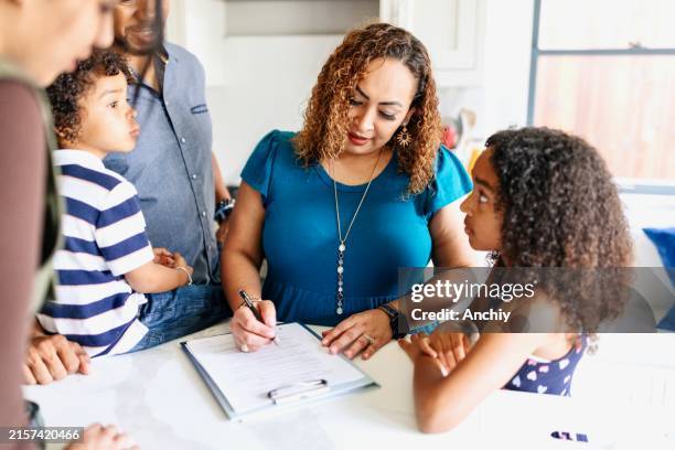 close-up of a woman signing an agreement to buy a new house - homeowners insurance stock pictures, royalty-free photos & images