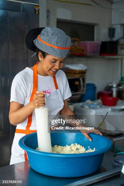 junge frau arbeitet in der küche mit ihrem neuen lebensmittelgeschäft - kolumbianische kultur stock-fotos und bilder