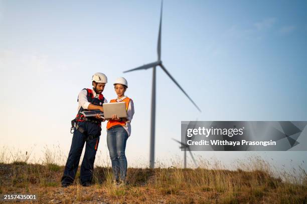 wind energy engineers working in wind farm at dusk. renewable energy systems. carbon neutrality and sustainable energy. - sustainable development goals stock pictures, royalty-free photos & images