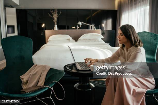 business woman using laptop in hotel room - quarto de hotel imagens e fotografias de stock