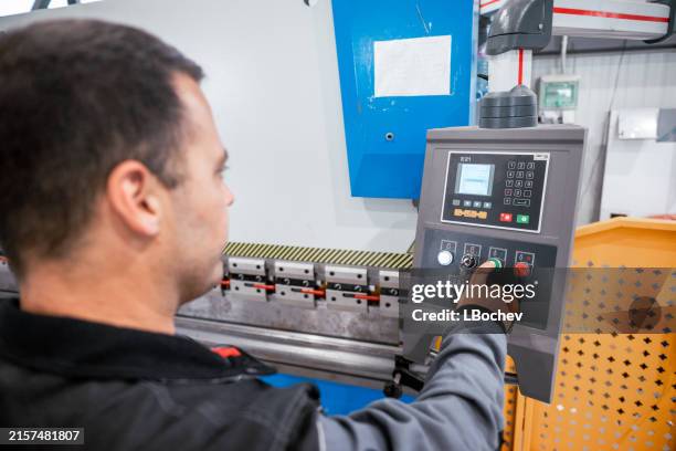 man is setting automated milling machine - metal worker stock pictures, royalty-free photos & images