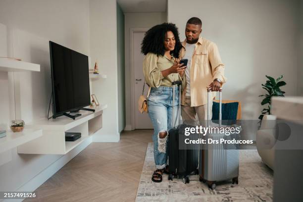 couple leaving home with suitcases for travel - handtasche stock-fotos und bilder
