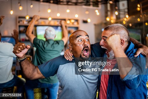 Senior fans men celebrating a goal on sports match on the bar Senior fans men celebrating a goal on sports match on the bar