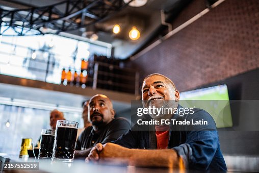 Senior man watching sports at bar Senior man watching sports at bar
