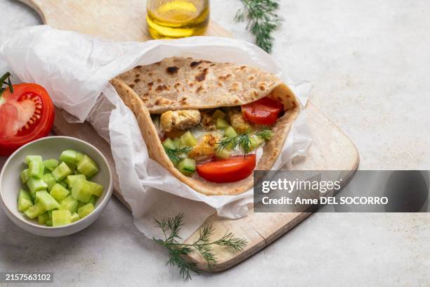 pita bread with chicken, salade, tzatziki, tomato, cucumber, yogurt sauce - pita stock-fotos und bilder