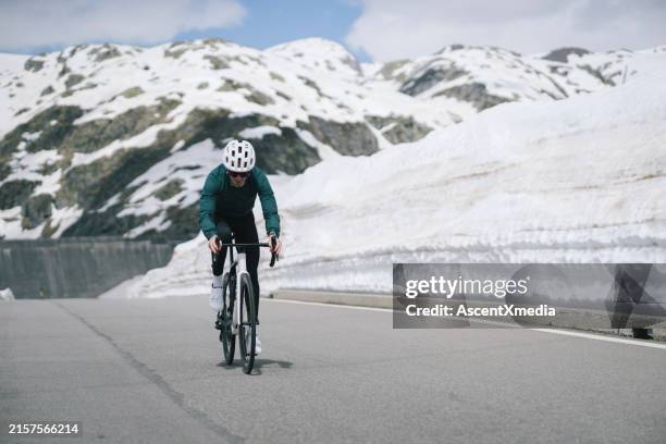 road biker rides to high mountain pass, gotthard pass - mountain pass stock pictures, royalty-free photos & images