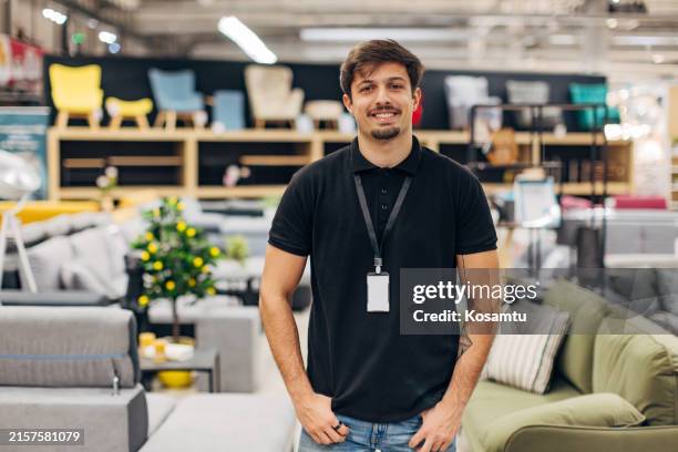 vue de face d’un beau vendeur debout dans un grand magasin et regardant directement la caméra - linge de lit photos et images de collection