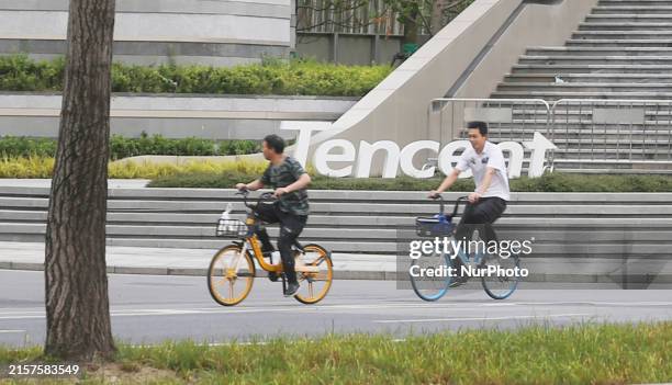 Citizens are walking past the Tencent headquarters building in Shanghai, China, on June 10, 2024.