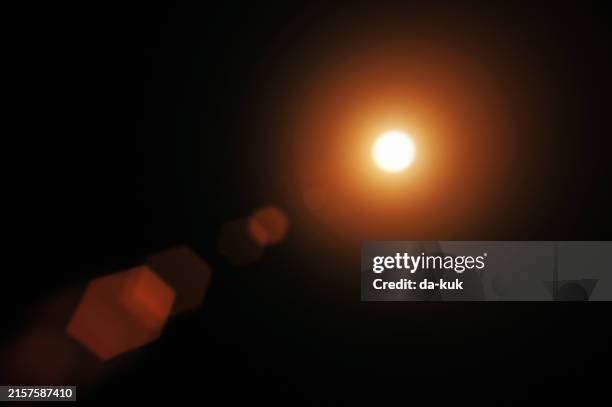 lens flare auf schwarzem hintergrund. overlay-designelement - blendenfleck stock-fotos und bilder