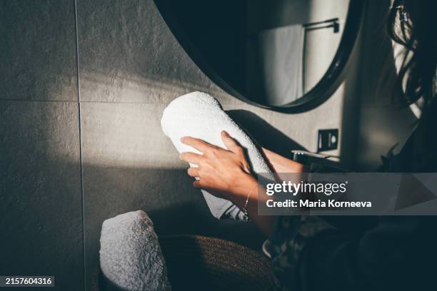 woman takes white bath towels in the bathroom. - luxury hotel service stock pictures, royalty-free photos & images