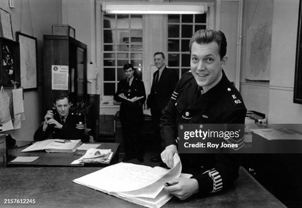 Police sergeant with other policemen inside Kentish Town Police Station, London, November 27th 1967.