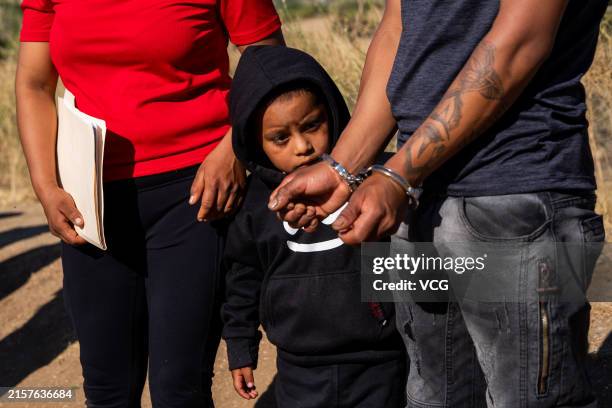 Child looks on as his father, who illegally crossed into the U.S. From Mexico, is arrested by U.S. Border Patrol agents on June 14, 2024 in Jacumba...