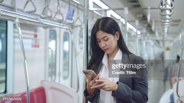 businesswoman using smartphone on train - only japanese stock pictures, royalty-free photos & images