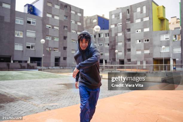 mid waist view of hispanic young dancer doing break dance in the suburb - distrito municipal tipo de distrito fotografías e imágenes de stock