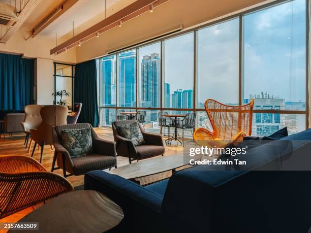creative co sharing workspace lounge with sofa and coffee table - warm light stock pictures, royalty-free photos & images