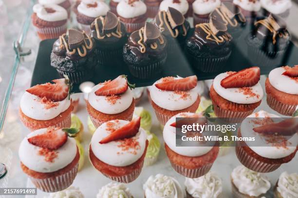 assorted gourmet cupcakes on display - pasticceria foto e immagini stock