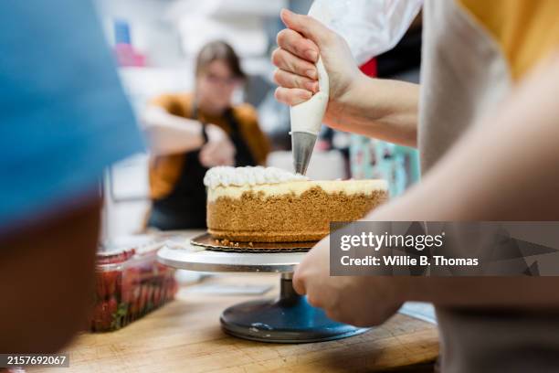 close-up of chef piping frosting on cheesecake - decorar um bolo imagens e fotografias de stock
