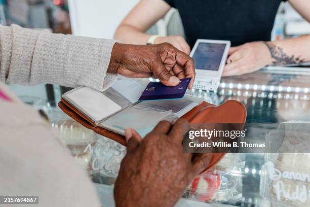 senior customer using credit card at bakery - day stock pictures, royalty-free photos & images
