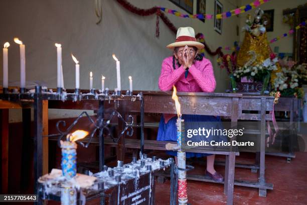 peruvian elderly woman of the quechua ethnic group praying with her hands on her face on her knees in the church - theology stock pictures, royalty-free photos & images