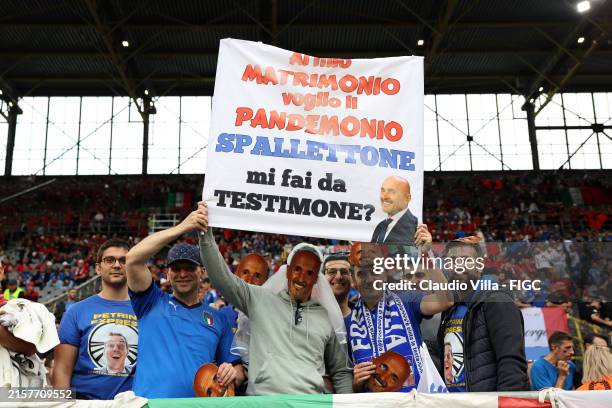 Fans of Italy, holding a sign which reads "I want Pandemonium at my Wedding, Spallettone You're my Best Man?", pose for a photo on the inside of the...
