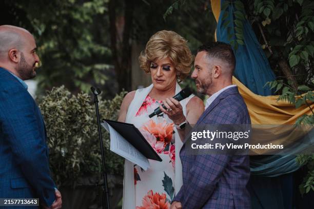 pareja gay intercambiando votos matrimoniales - promesas de matrimonio fotografías e imágenes de stock