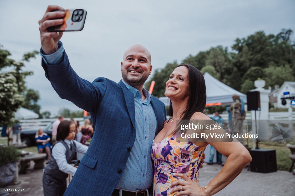 Groom taking selfies with his sister at wedding reception