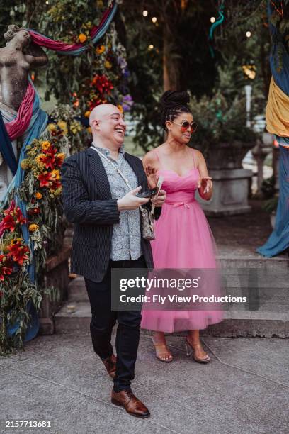 wedding guests laughing while attending outdoor reception - wedding guest stock pictures, royalty-free photos & images