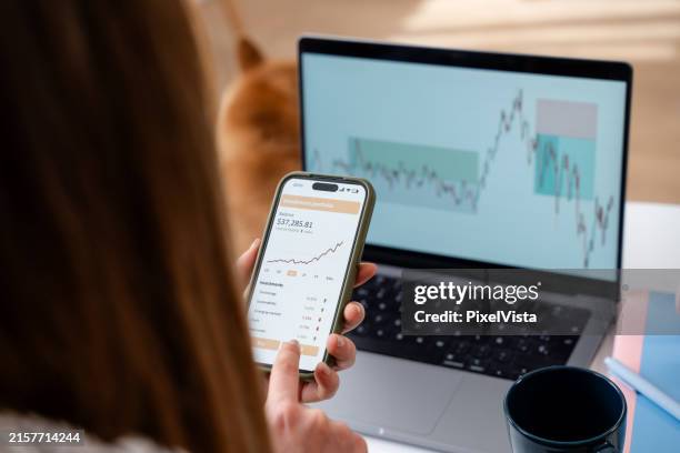 frau, die das wachstum des anlageportfolios auf der handy-app zu hause überprüft - fondsmanager stock-fotos und bilder