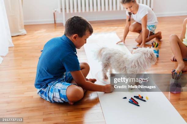 children having fun drawing on a paper while sitting on the floor - coloring crayons stock pictures, royalty-free photos & images