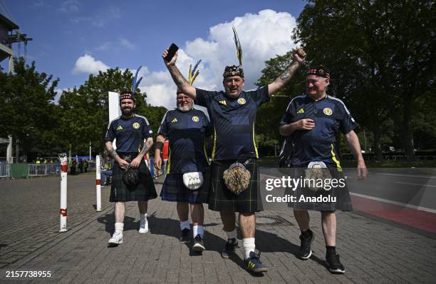 Football supporters, wearing jerseys and kilts, arrive the RheinEnergieStadion, where the UEFA EURO 2024 Group A match between Scotland and...