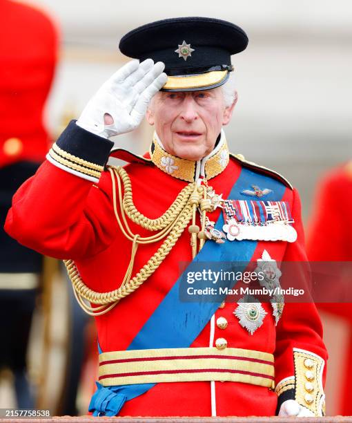 King Charles III, wearing his Irish Guards uniform, takes the salute from a dais outside Buckingham Palace after Trooping the Colour on June 15, 2024...