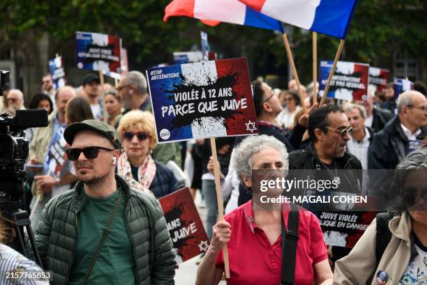 Protesters hold placards which read Raped because she was Jewish during a rally to condemn the alleged anti semetic gang rape of a 12 year old girl,...
