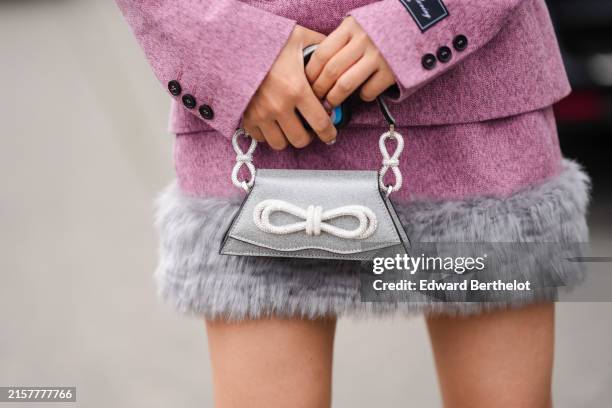 Lin Lin Yujing, wears a pink MSGM buttoned up fitted blazer with black buttons, a pink MSGM skirt with gray faux fur, a small silver bag with shiny...