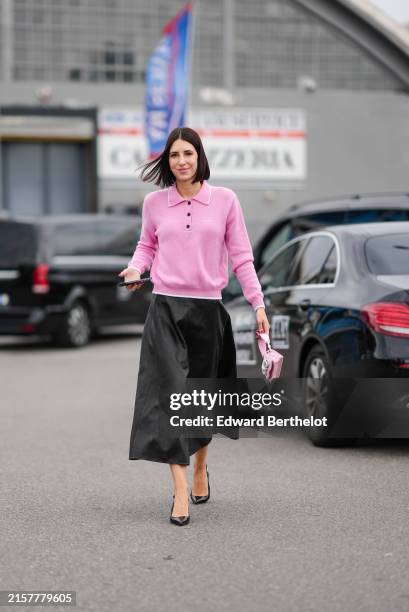 Francesca Busi wears a white three buttoned long sleeved cropped sweater, black midi skirt, small pink bag with shiny silver bow, black shiny heels,...