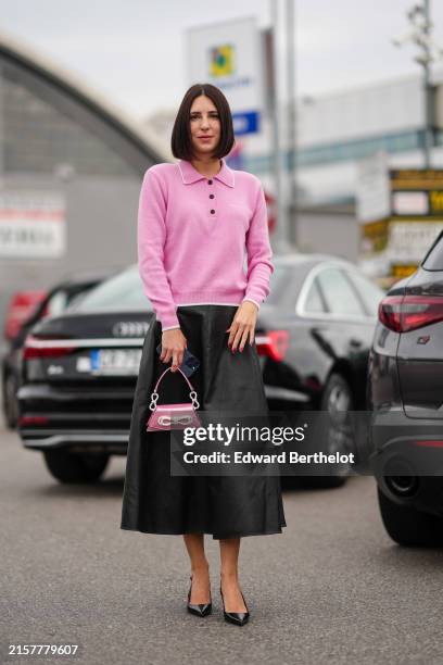 Francesca Busi wears a white three buttoned long sleeved cropped sweater, black midi skirt, small pink bag with shiny silver bow, black shiny heels,...