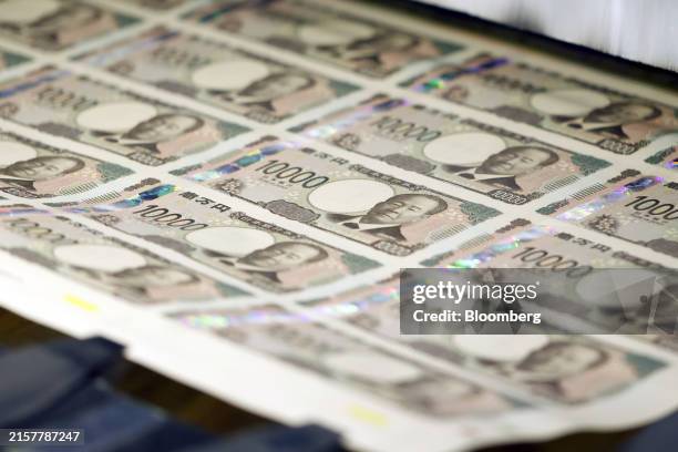 Sheets of newly-designed Japanese 10,000 yen banknotes, with three-dimensional holographic technology to prevent forgery, move through a machine at...