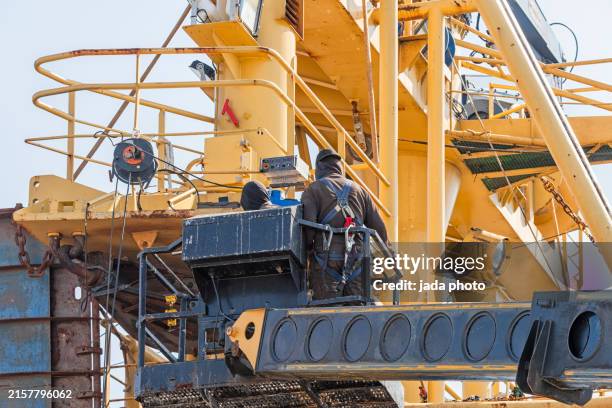 two people secured with safety equipment on board of a ship - aboard stock pictures, royalty-free photos & images
